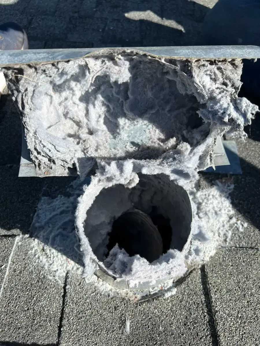 Dryer vent outlet packed with compacted lint before cleaning